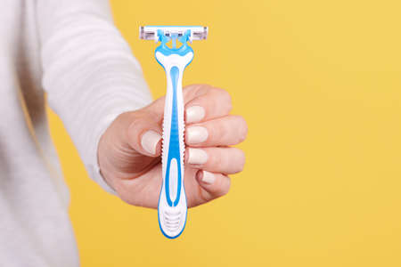 Hand with blue disposable razor.の写真素材