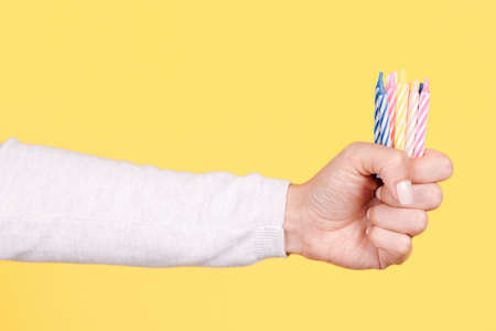 Hand with colored birthday candles.の写真素材