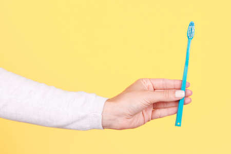 Hand with blue toothbrush, dental care.の写真素材