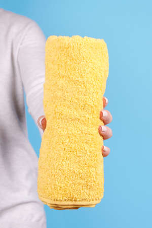 Hand with folded yellow towel.の写真素材