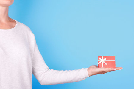 Hand with red gift box.