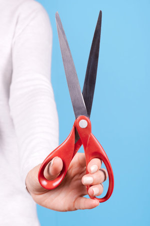 Hand with red scissors. Isolated.