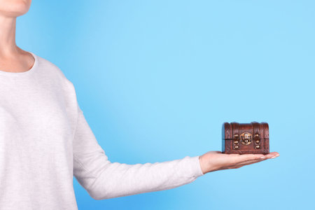 Hand with wooden chest, casket.