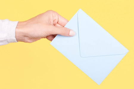Hand with blue paper envelope.