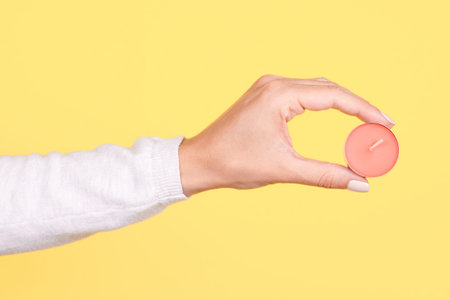 Hand with pink aroma candle.