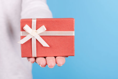 Hand with red gift box.