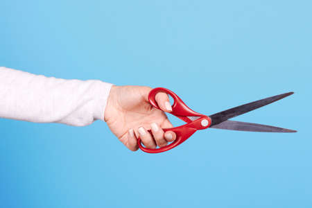 Hand with red scissors. Isolated.の写真素材