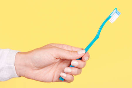 Hand with blue toothbrush, dental care.の写真素材