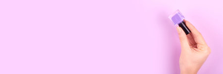 Hand with nail polish bottles. Flat lay.