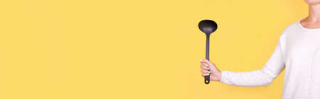 Black plasic ladle in hand.の写真素材