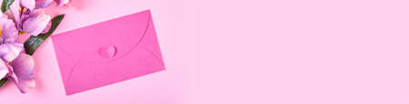 Envelope and flowers on pink background composition.の写真素材