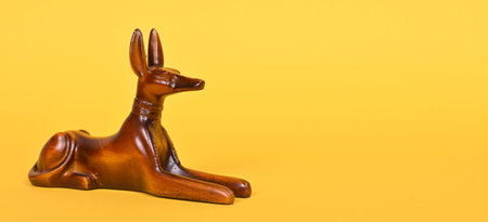The ancient God of Egypt Anubis, a statue of a dog on a yellow background.の写真素材