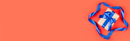 Gift box on red background composition, present with ribbon and bow. Flat lay and top view photo...