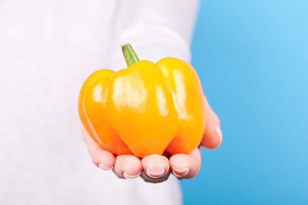 Hand with fresh ripe orange pepper.の写真素材