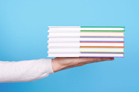 Hand with stack of books.