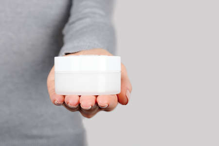 Hand with white cream bottle.の写真素材