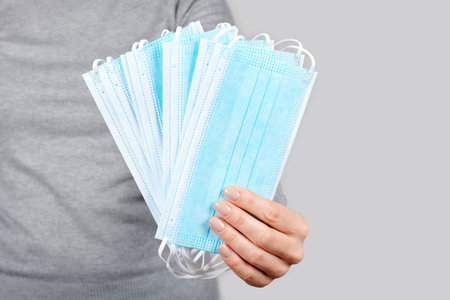 Hand with protective facial mask.