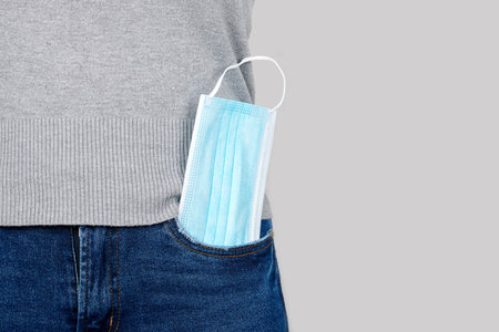 Medicine protective mask in jeans pocket.