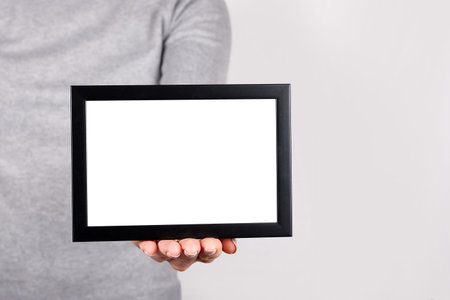 Hand with black frame on grey.