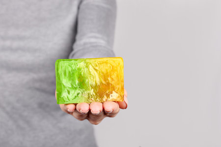 Hand with handmade soap on grey.の写真素材