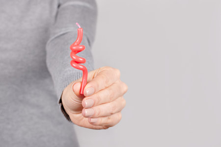 Hand with red candle on grey.の写真素材