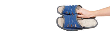 Hand with domestic comfort slippers isolated on white.の写真素材