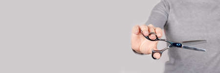 Hand with thinning scissors on grey.の写真素材