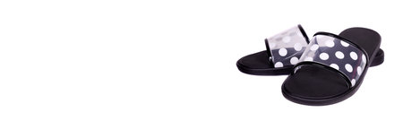 Black slippers with dotted pattern.
