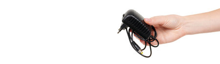 Hand with black power adapter isolated on white.