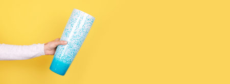 Hand with turquoise glass vase.