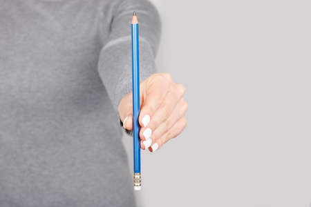 Hand with office pencil on greyの写真素材