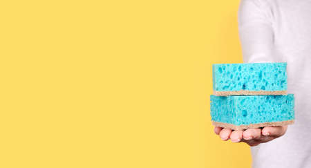 Hand with turquoise cleaning sponge.の写真素材