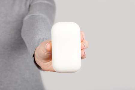 Hand with white soap on grey