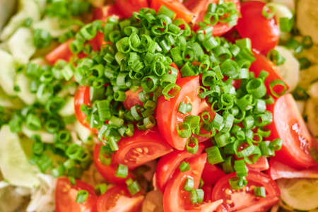 Macro photo of fresh red tomatoes and green onions salad.の写真素材