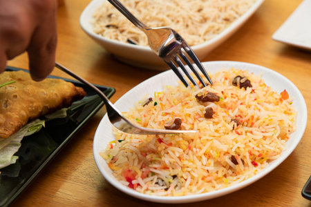 Serving pilau rice from a white tray on a pakistani restaurant tableの写真素材