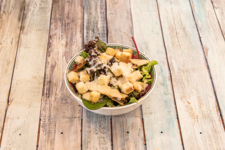 Small bowl of cesar salad with the usual ingredients on wooden backgroundの写真素材
