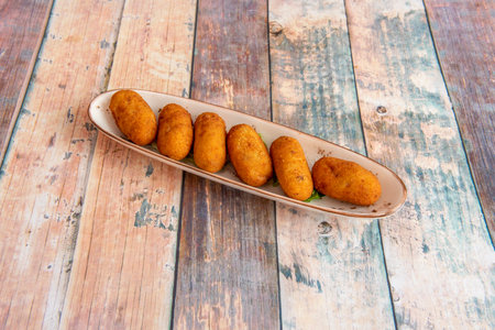 elongated tray tailored to the croquettes served as Spanish tapas on a wooden tableの写真素材