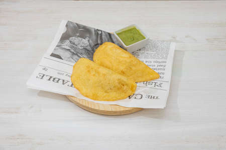Colombian cornmeal empanadas with dip sauce on wood plateの写真素材