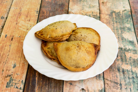 Very plump Spanish dumplings stuffed with meat or bonito with a few sesame seeds decorating the...