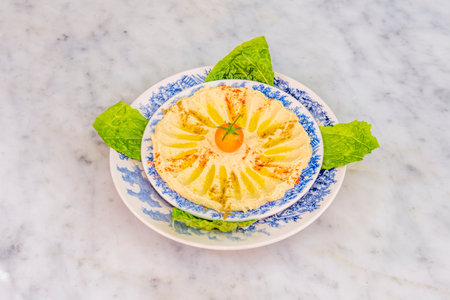 Chickpea hummus with olive oil, paprika, ras el hanout and cherry tomato and lettuce to dip on...