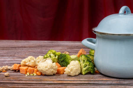Pot and ingredients to make a vegetable stew on wooden tableの写真素材