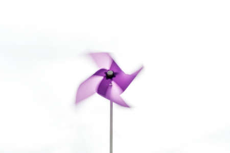 Purple pinwheel turning its blades under the effect of a light breezeの写真素材