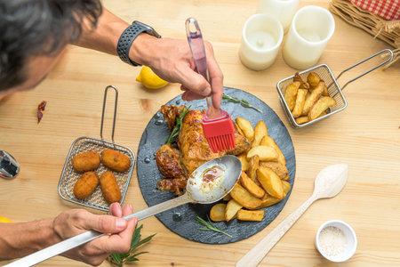 Top view image of chef putting together a plate of roast chicken with deluxe potatoes and leaving it cool for the photoの写真素材