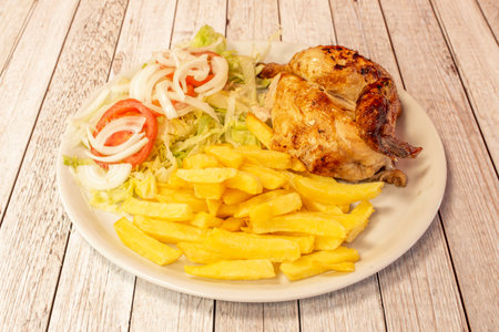 Pakistani restaurant menu with half roast chicken, french fries and salad on wooden table