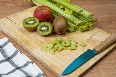 Ripe and healthy fruits plus celery to prepare a detox juice on wooden boardの写真素材