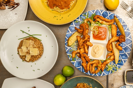 Top view image of squid squid with sauces, creamy rice with cured cheese flakes, spaghetti with...