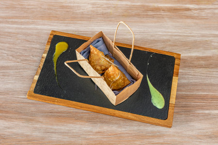 Samosas in recycled paper trompe l'oeil bag for home delivery
