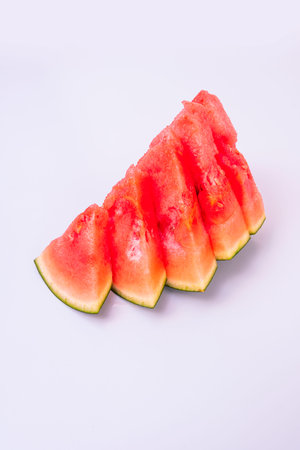 Ragged pieces of red seedless watermelon on pastel gray backgroundの写真素材