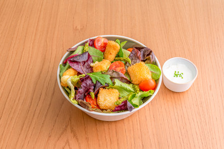 mixed lettuce sprout salad, chicken nuggets, green asparagus, cherry tomatoes and mayonnaise sauceの写真素材