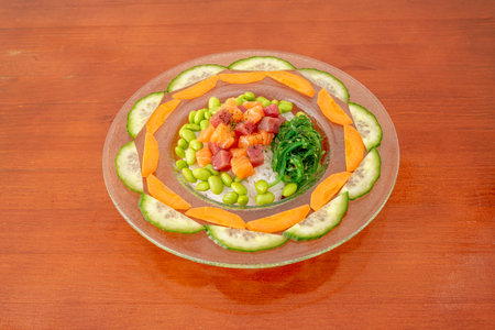 Curious presentation of poke bowl on a plate with cucumber and carrot slices, marinated salmon and...